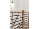 Close-up of a modern staircase featuring wood and metal railings, lit by a wall sconce at 2327 Mason Dr # D23, Atlanta, GA 30316