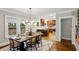 Dining room with decorative light fixture adjacent to kitchen with warm wood cabinetry and bar seating at 608 Sherwood Ne Rd, Atlanta, GA 30324