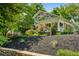 Landscaped front yard featuring a stone wall, mulch beds, and mature trees surrounding a two-story home at 608 Sherwood Ne Rd, Atlanta, GA 30324