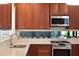 Bright kitchen featuring sleek countertops, stainless steel appliances, and a row of small plants in front of a long window at 608 Sherwood Ne Rd, Atlanta, GA 30324
