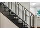 Modern staircase with dark wood steps, light carpet runner and decorative black metal railing at 608 Sherwood Ne Rd, Atlanta, GA 30324