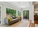 Bright sun room featuring large windows, a comfortable sofa, hardwood floors, and modern decor at 608 Sherwood Ne Rd, Atlanta, GA 30324