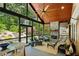 Inviting sunroom with vaulted wood ceilings, stone fireplace, and scenic views of the landscaped backyard at 608 Sherwood Ne Rd, Atlanta, GA 30324
