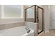 A well-lit bathroom features a soaking tub and a tiled shower with glass door at 6100 Misty Hill Ln, Buford, GA 30518