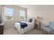 Bright bedroom with two windows, comfortable bed, and a blue throw blanket at 6100 Misty Hill Ln, Buford, GA 30518
