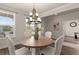 Cozy dining room features a modern chandelier, wooden table, and ample natural light at 6100 Misty Hill Ln, Buford, GA 30518