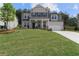 Two-story home boasts a well-manicured lawn, neutral colors, and a classic architectural design at 6100 Misty Hill Ln, Buford, GA 30518