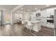 Open kitchen features an island with seating, stainless steel appliances, and wood flooring at 6100 Misty Hill Ln, Buford, GA 30518