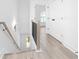 Hallway features light hardwood floors, white walls, a staircase with wood railing and a closet with black hardware at 3319 Stillwood Ln, Hapeville, GA 30354