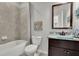 Cozy bathroom with bathtub and shower with gray tile, wooden framed mirror, and a beach-themed decor at 4050 Pleasant Woods Dr, Cumming, GA 30028
