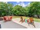A spacious backyard featuring a deck with seating under mature trees at 4525 E Point Dr, Cumming, GA 30041