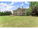 Well-manicured lawn leads to a large home with a spacious backyard and mature trees at 4525 E Point Dr, Cumming, GA 30041