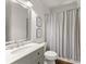 Bathroom with a sink, commode, mirror, and shower featuring gray and white striped shower curtain at 4525 E Point Dr, Cumming, GA 30041