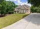 Wide driveway leading to a well-maintained two-story house with a neatly landscaped front yard at 4525 E Point Dr, Cumming, GA 30041