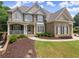 Stunning two-story brick home with a manicured lawn, inviting porch, and beautifully landscaped surroundings at 4525 E Point Dr, Cumming, GA 30041