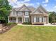 Charming two-story brick home with a manicured lawn, inviting porch, and meticulously maintained landscaping at 4525 E Point Dr, Cumming, GA 30041