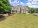 Beautiful front yard with lush lawn and landscaping leading up to the attractive brick facade of the home at 4525 E Point Dr, Cumming, GA 30041