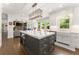 Open kitchen offers island seating and seamless connectivity to the living room with a stone fireplace at 4525 E Point Dr, Cumming, GA 30041