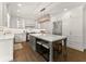 Stunning white kitchen features a large center island with seating, stainless steel appliances, and custom cabinets at 4525 E Point Dr, Cumming, GA 30041