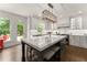 Well-lit kitchen features a marble island countertop, wooden floors, stainless steel appliances, and backyard view at 4525 E Point Dr, Cumming, GA 30041