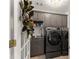 Laundry room with gray cabinets and large capacity washer and dryer at 4525 E Point Dr, Cumming, GA 30041