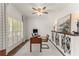 A bright home office with plantation shutters, a ceiling fan, and built-in storage cabinets at 4525 E Point Dr, Cumming, GA 30041