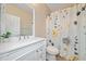 Clean bathroom with a white vanity, stylish mirror, and a floral patterned shower curtain at 508 Canton Ct, Canton, GA 30115