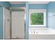 Bathroom featuring a shower, bathtub, window, and blue painted walls at 508 Canton Ct, Canton, GA 30115