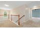 Upstairs hallway featuring wood railing, carpeted floors, and an arched window for natural light at 508 Canton Ct, Canton, GA 30115