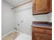 Compact laundry area with wooden cabinets and tile floor at 508 Canton Ct, Canton, GA 30115