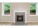 Living room featuring a cozy fireplace, hardwood flooring, and bright windows with backyard views at 508 Canton Ct, Canton, GA 30115