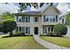 Charming two-story home featuring a well-manicured lawn, inviting front door, and symmetrical window design at 1311 Bustling Sw Ln, Marietta, GA 30064