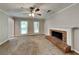 Bright living room with a classic brick fireplace and ceiling fan provides a warm, inviting atmosphere at 1311 Bustling Sw Ln, Marietta, GA 30064