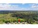 Aerial view of homes, set amongst a lush forest with a stunning blue sky at 1686 Brooks Farm Nw Dr, Acworth, GA 30101