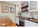 Close up of basement bar with countertop seating, mini fridge, and shelving at 1686 Brooks Farm Nw Dr, Acworth, GA 30101