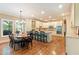 Open-concept kitchen and dining area with stainless appliances, granite counters, and hardwood floors at 1686 Brooks Farm Nw Dr, Acworth, GA 30101