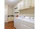 Well-equipped laundry room with washer, dryer, cabinets, hanging hooks and hardwood floors at 1686 Brooks Farm Nw Dr, Acworth, GA 30101