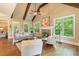 Light filled living room with exposed wood beams, fireplace, and beautiful hardwood flooring at 1686 Brooks Farm Nw Dr, Acworth, GA 30101