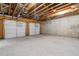Unfinished basement with exposed ceiling, concrete floor, and two garage doors at 364 Glendale Ne Ave # B, Atlanta, GA 30307