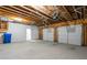 Unfinished basement featuring exposed ceiling, concrete floor, two garage doors and a white door leading to a room at 364 Glendale Ne Ave # B, Atlanta, GA 30307