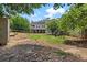 Expansive backyard with a large lawn, mature trees, and a view of the home's exterior at 944 Hidden Falls Se Ln, Smyrna, GA 30082
