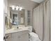 Well-lit bathroom with vanity, toilet, and shower with a neutral-colored shower curtain at 944 Hidden Falls Se Ln, Smyrna, GA 30082