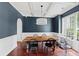 Elegant dining room with dark blue walls, white wainscoting, a modern chandelier, and hardwood floors at 944 Hidden Falls Se Ln, Smyrna, GA 30082