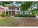 Two-story home with covered porch and stone accents, surrounded by mature trees and well-maintained landscaping at 944 Hidden Falls Se Ln, Smyrna, GA 30082