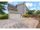 View of the garage and driveway with well-kept landscaping on a sunny day at 944 Hidden Falls Se Ln, Smyrna, GA 30082
