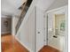 Hallway with hardwood floors and staircase leading to an open door of the laundry room at 944 Hidden Falls Se Ln, Smyrna, GA 30082