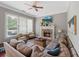 Comfortable living room features a stone fireplace, large windows, and a ceiling fan at 944 Hidden Falls Se Ln, Smyrna, GA 30082