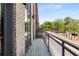 View of the outdoor balcony with metal railings that overlooks a city street with green trees at 1225 Chelsea Nw Cir, Atlanta, GA 30318