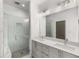A modern bathroom with gray cabinets, a large mirror, and a glass-enclosed shower at 1225 Chelsea Nw Cir, Atlanta, GA 30318