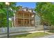 Charming two-story home with a double porch, white picket fence, and mature trees under a bright blue sky at 1858 Perry Nw Blvd, Atlanta, GA 30318